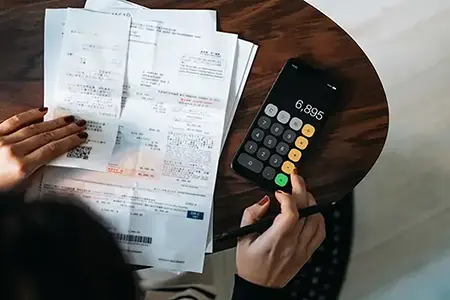 hands with receipts and a calculator